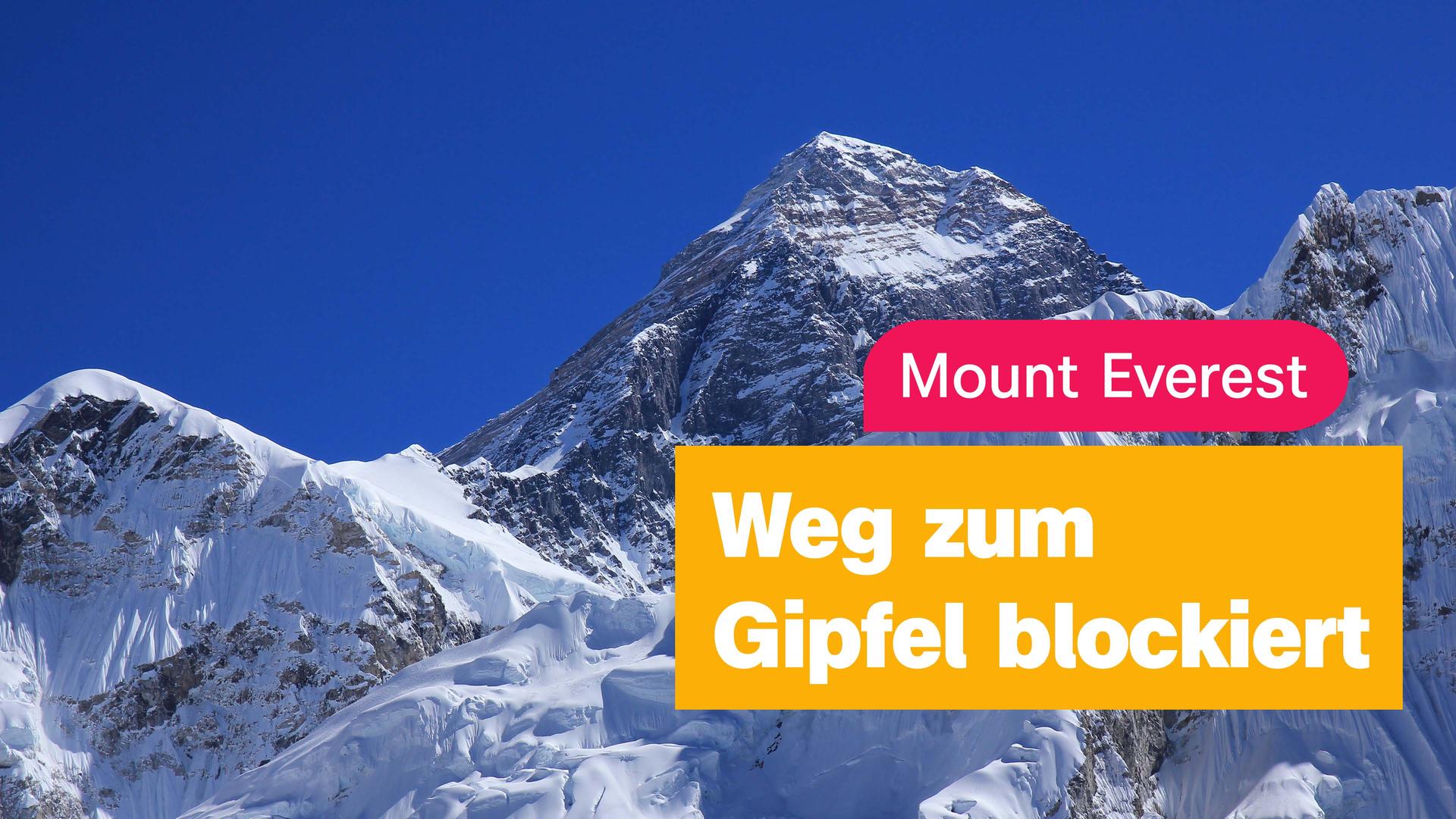 Strahlend blauer Himmel und ein schneebedecktes Bergmassiv. Darüber eine pinke Textbox "Mount Everest" und eine orangefarbene "Weg zum Gipfel blockiert". Unten die Info "logo!, 27.04.2026"