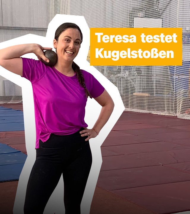 Teresa hält eine Kugel mit dem rechten Arm auf die Schulter gestemmt und lächelt in die Kamera. Rechts der Text "Teresa testet Kugelstoßen".