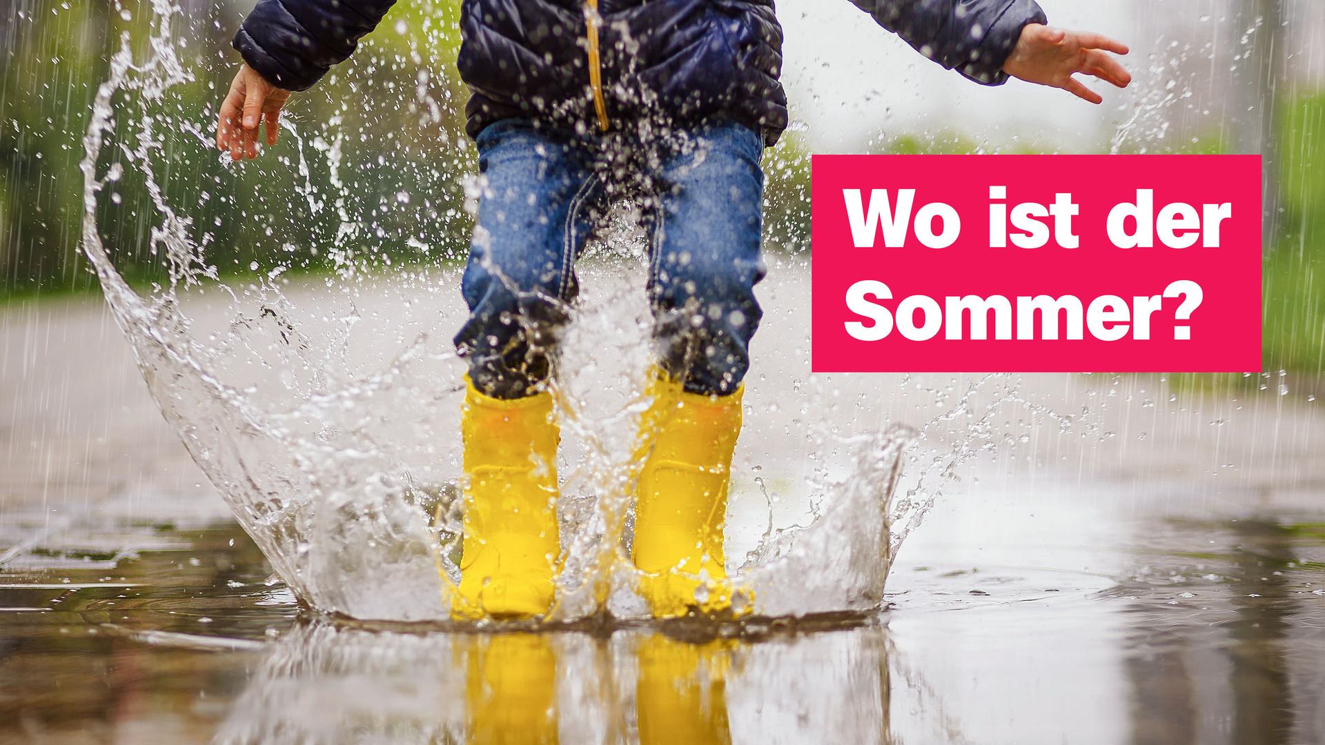 Ein Kind mit gelben Gummistiefeln und blauer Jeans hüpft fröhlich in eine Pfütze. Wasser spritzt hoch, während es eine dunkle Jacke trägt. Rechts im Bild steht der Text „Wo ist der Sommer?“ auf pinkem Hintergrund.