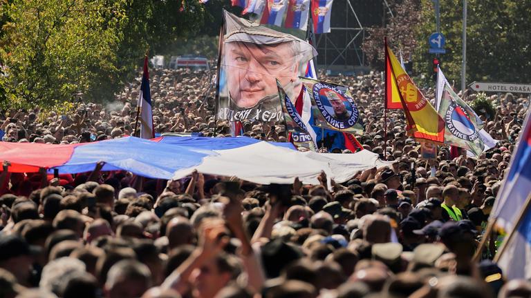 Viele Menschen mit Flaggen und Plakaten von Mladić