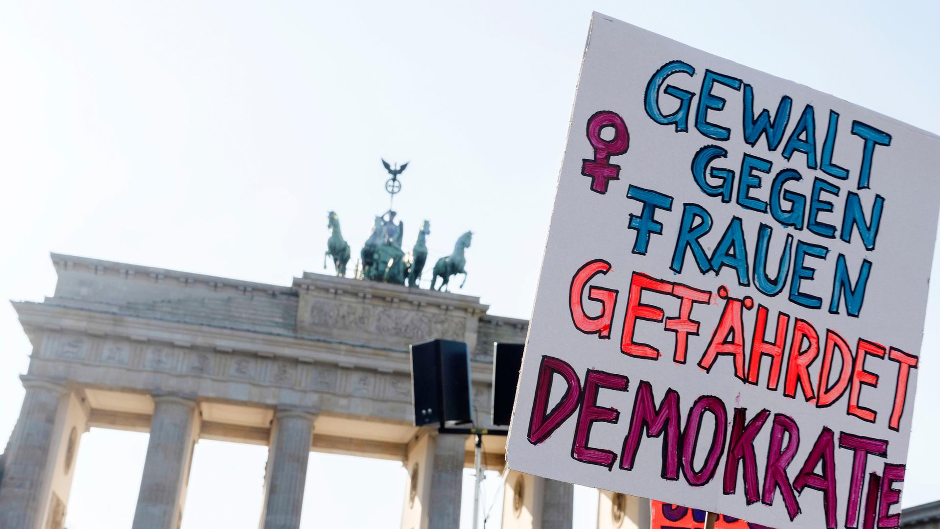 Neben einem steinernen Tor sieht man ein Demoplakat.