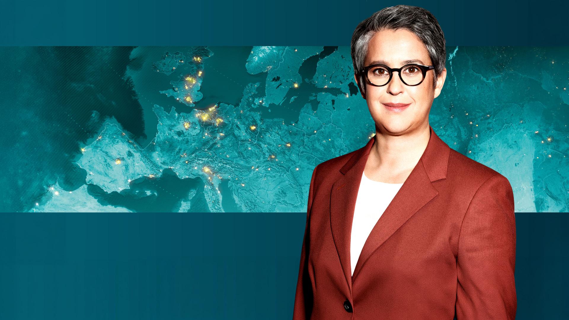 Shakuntala Banerjee vor einer Weltkarte.