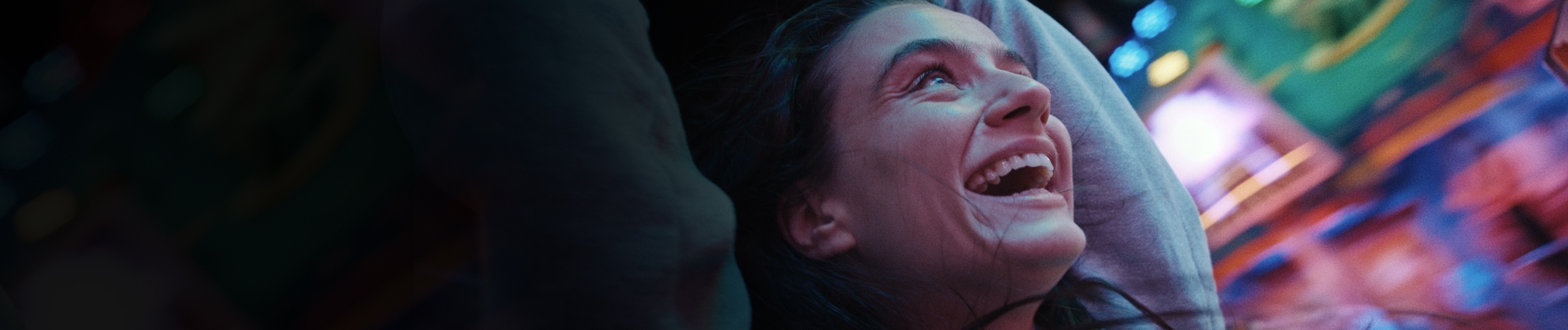 "Zwischen uns die Nacht": Marie (Laura Balzer) steht unter einem Fahrgeschäft und sieht nach oben. Sie ist in blaues Licht getaucht.