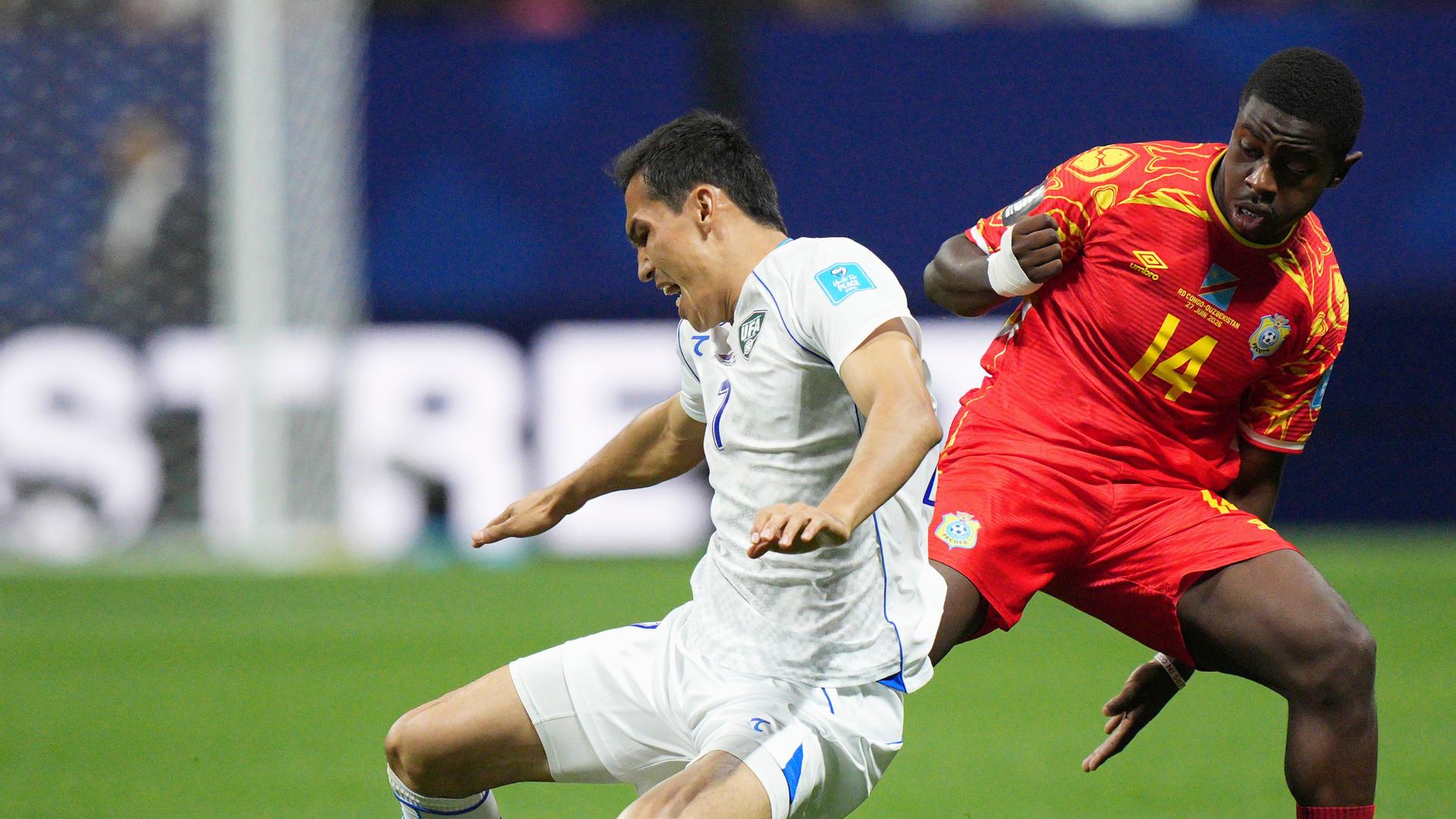 Der kongolesische Nationalspieler Noah Sadiki bringt seinen usbekischen Kontrahenten Otabek Shukurov im Zweikampf zu Fall