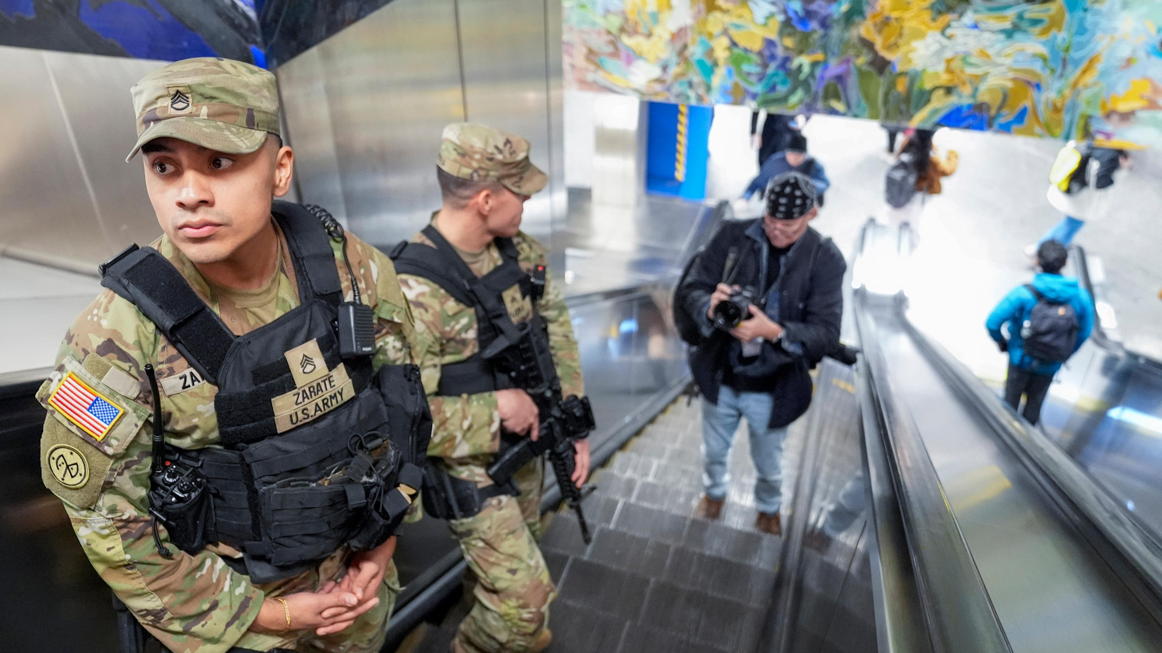 Schwer bewaffnete Sicherheitskräfte auf der Rolltreppe einer New Yorker U-Bahnstation