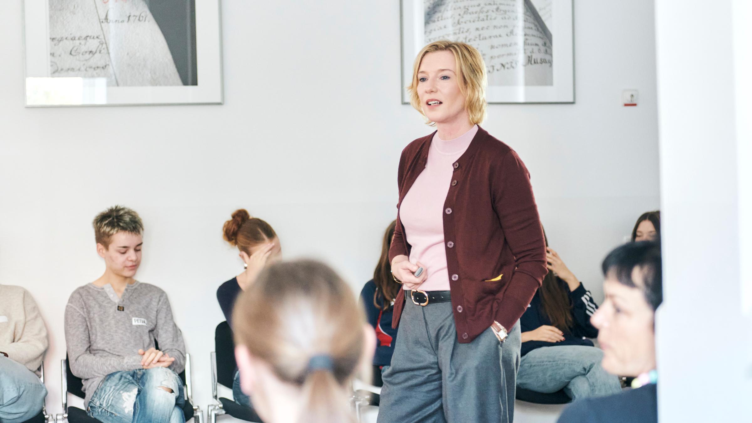 Das ZDF auf dem Silbersalz Festival 25: Moderatorin Christina von Ungern-Sternberg steht in der Mitte von Schüler, die auf Stühlen sitzend zuhören.