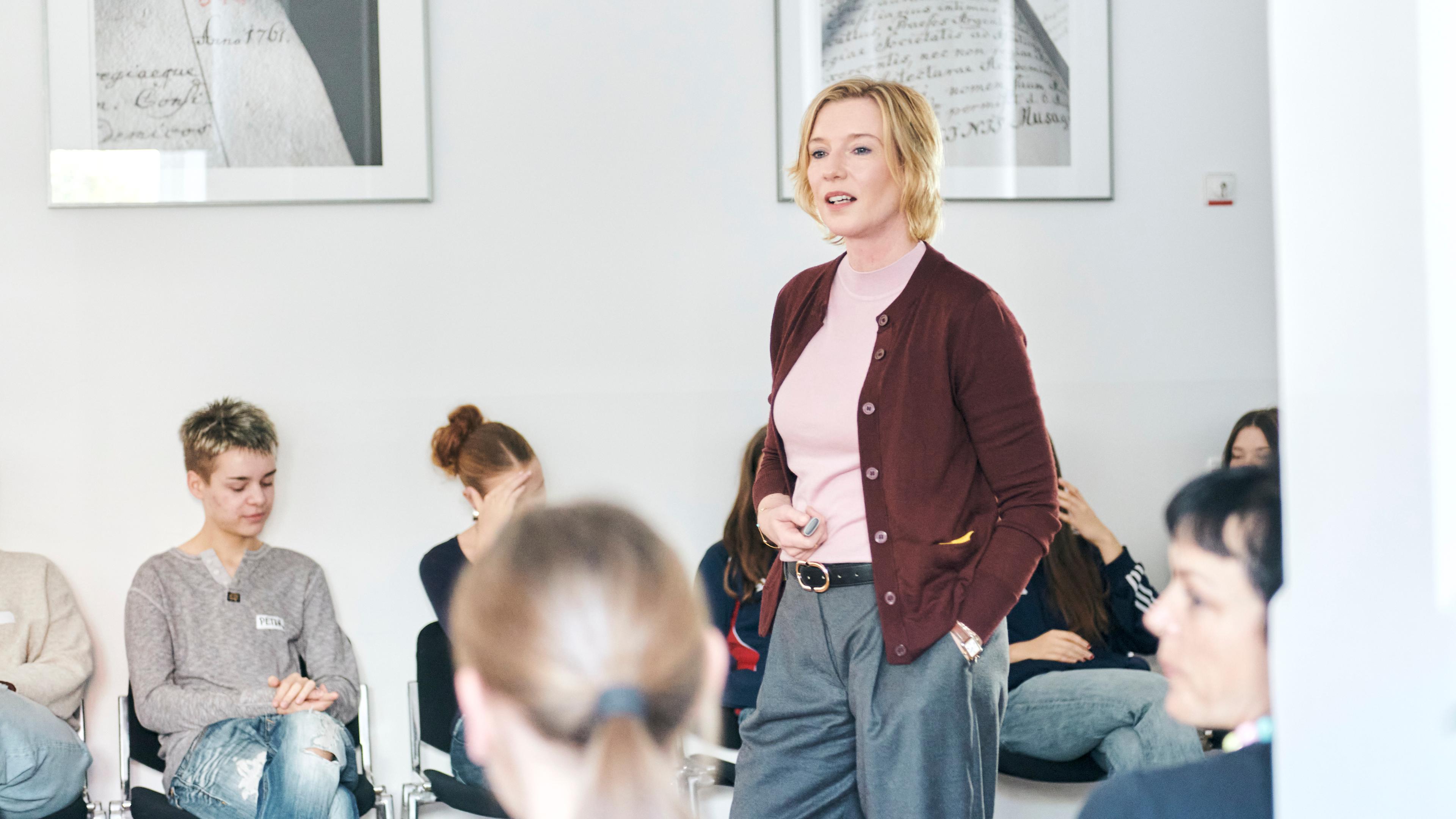 Das ZDF auf dem Silbersalz Festival 25: Moderatorin Christina von Ungern-Sternberg steht in der Mitte von Schüler, die auf Stühlen sitzend zuhören.