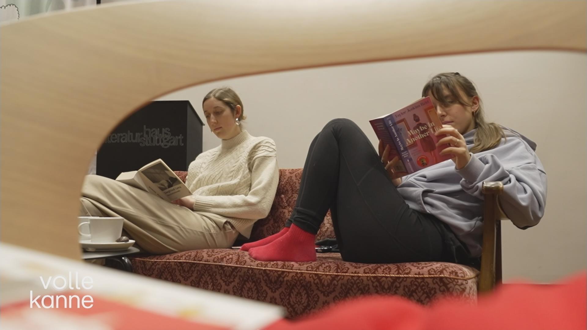 Zwei Frauen lesen auf einem Sofa