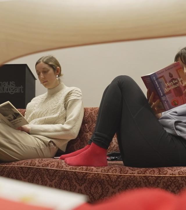 Zwei Frauen lesen auf einem Sofa