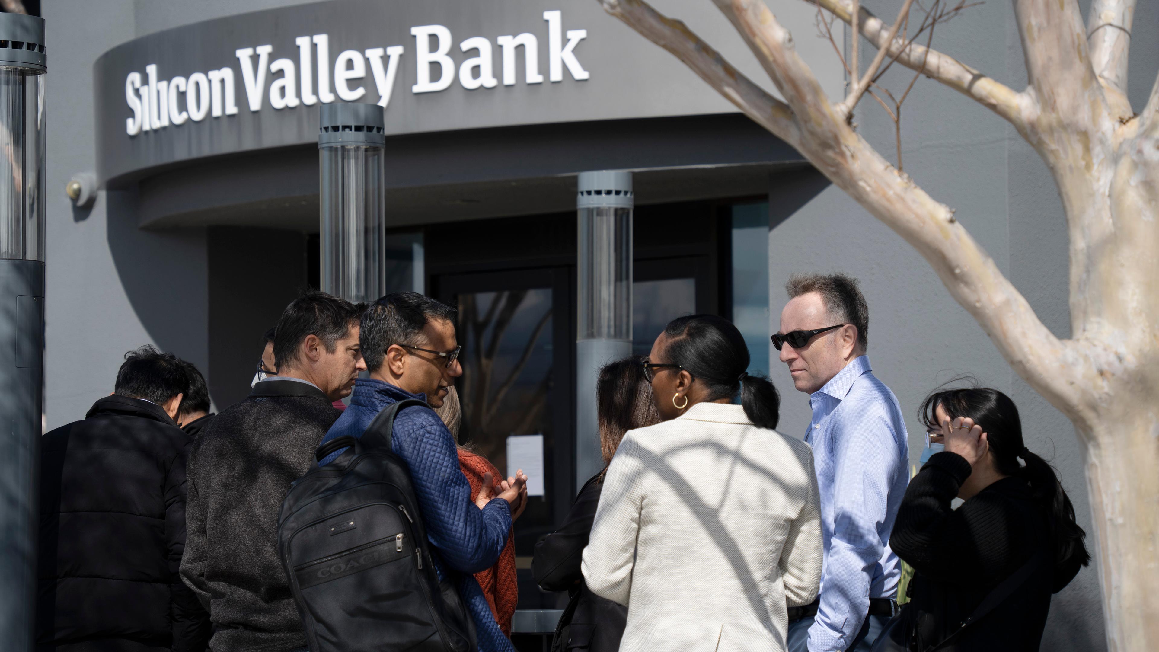 Das Bild zeigt Menschen, die vor dem Hauptsitz der Silicon Valley Bank Schlange stehen.