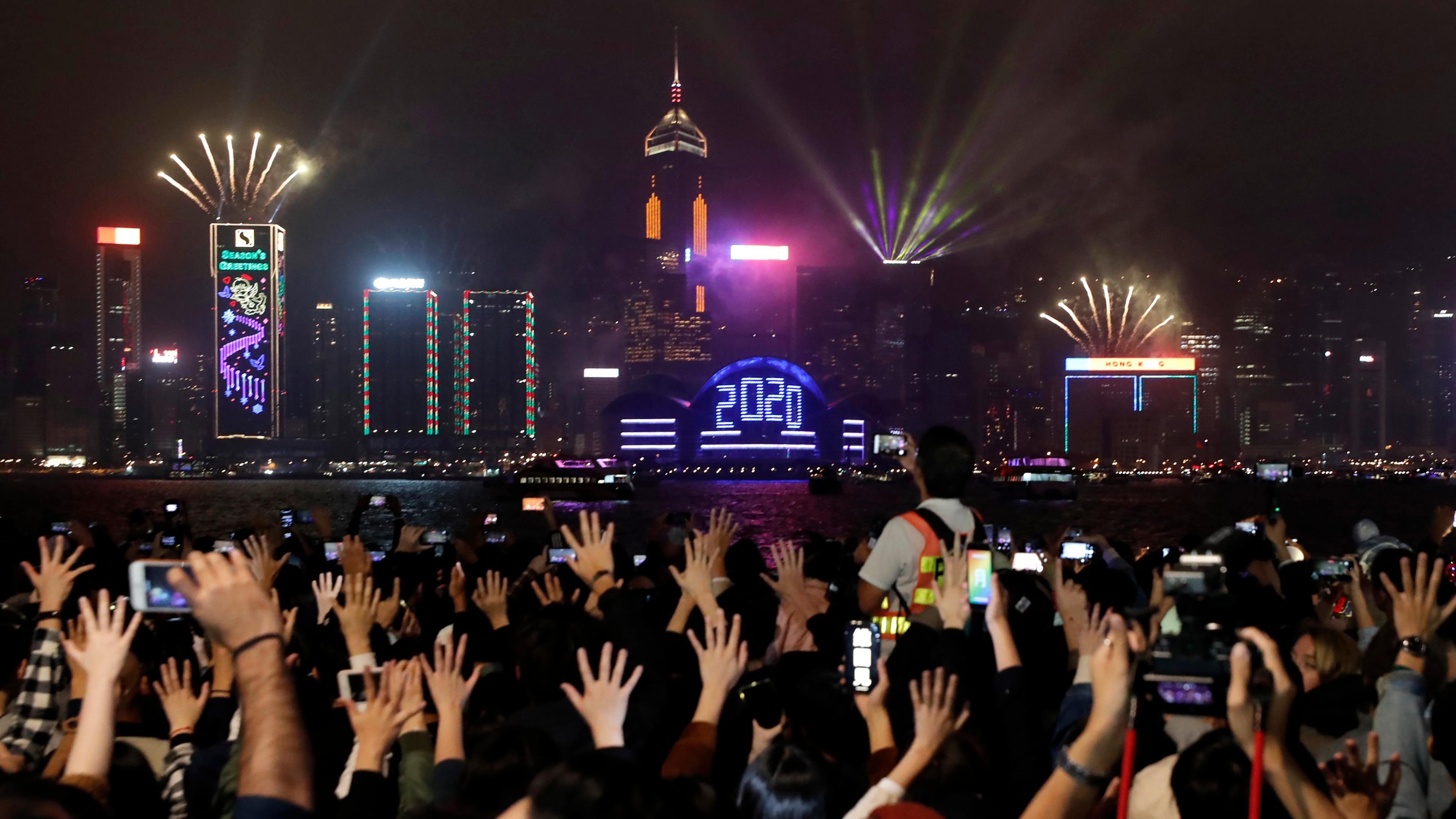 01.01.2020, china, hongkong: regierungskritische demonstranten halten waehrend feierlichkeiten zu neujahr ihre haende in die hoehe. 