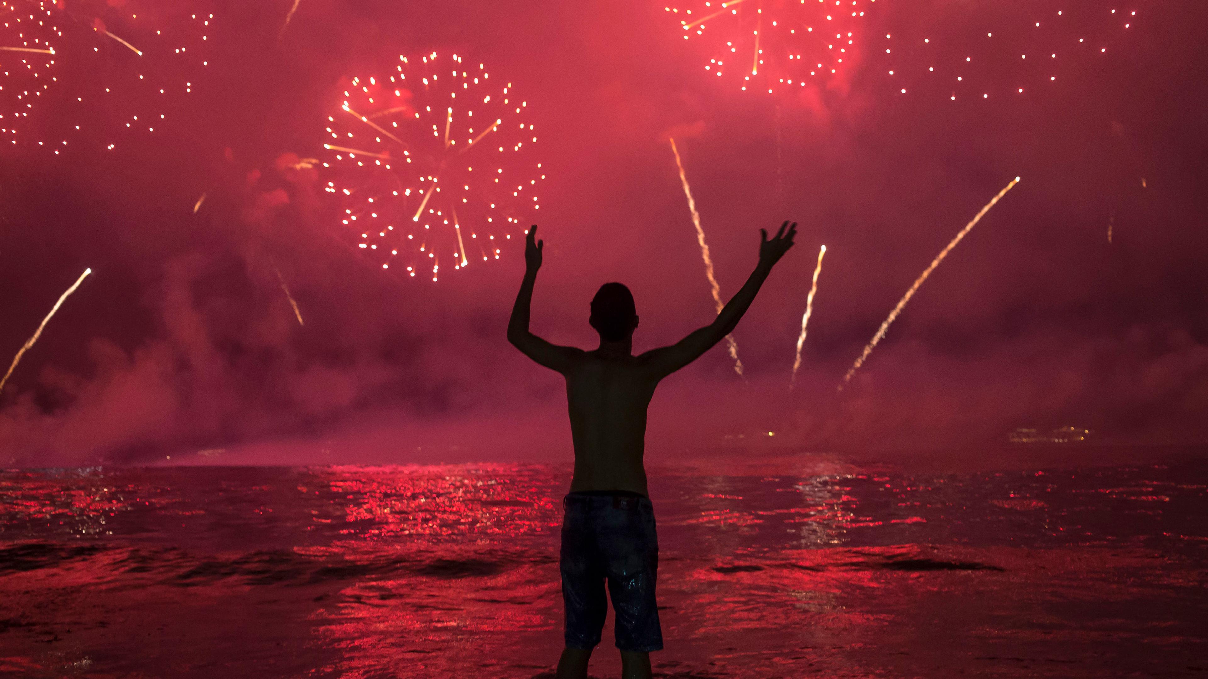 Ein Mann bestaunt das Feuerwerk zum Jahreswechsel in Rio de Janeiro.