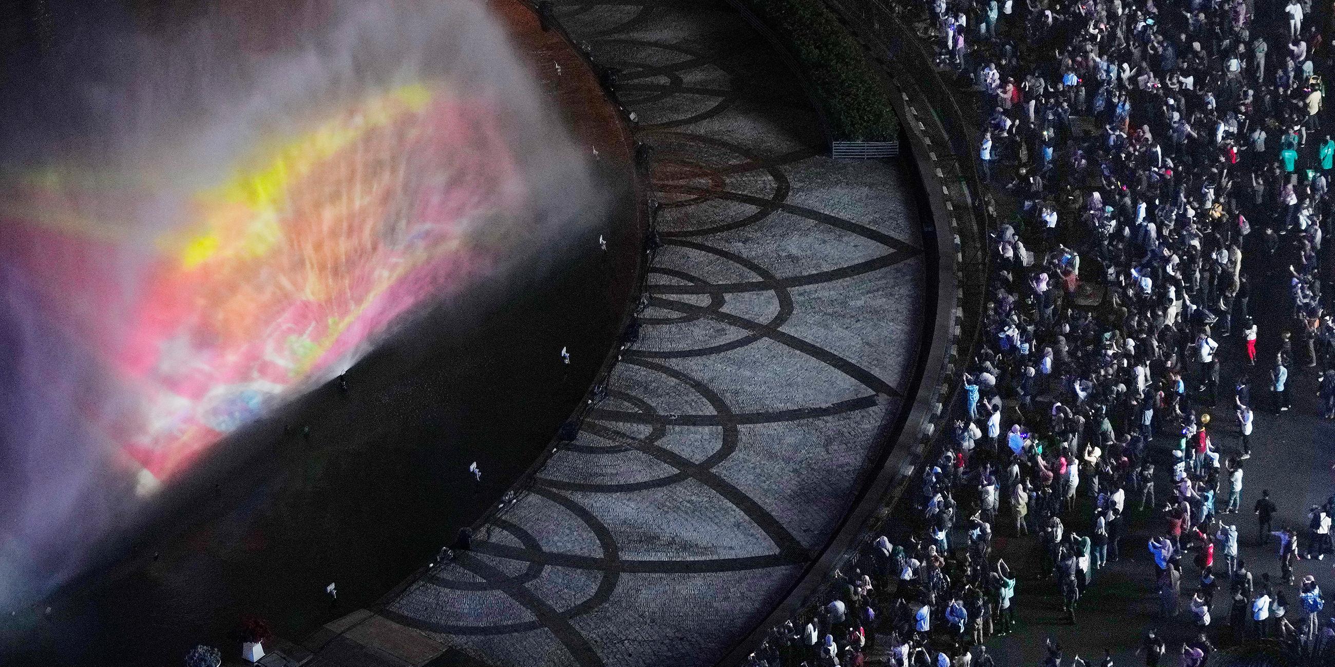 In Djakarta treffen sich Feierlustige an einem beleuchteten Springbrunnen.