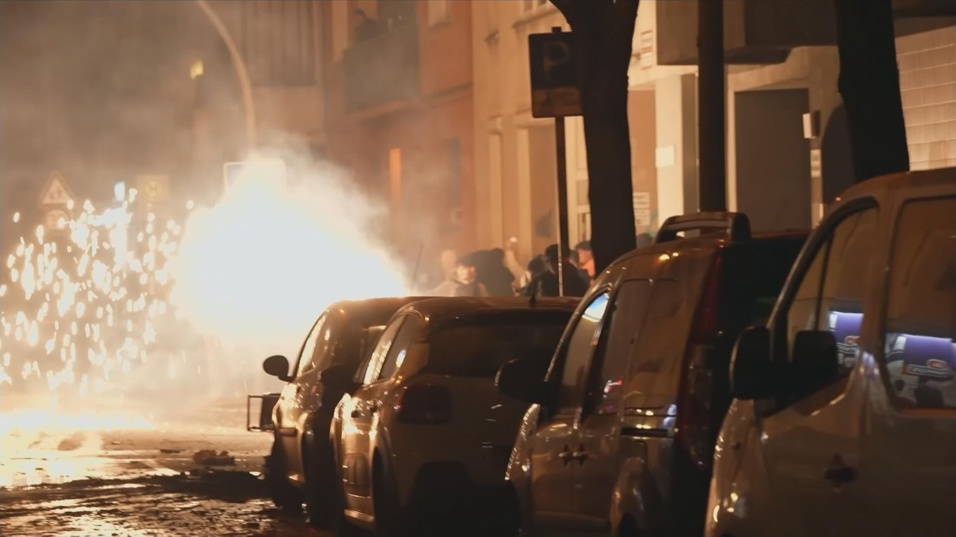 Autos vor explodierenden Feuerwerkskörpern.