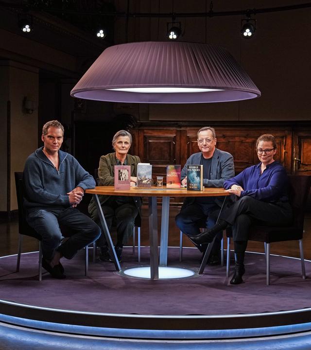 Die Gäste Simon Strauß, Iris Radisch, Matthias Brandt und Gastgeberin Thea Dorn sitzen an einem Tisch, auf dem die im Literarischen Quartett am 2.10. besprochenen Bücher liegen.