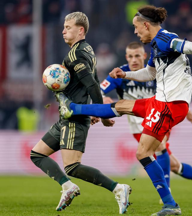 Hamburgs Stürmer Yussuf Poulsen versucht im Zweikampf mit Unions Stürker Tim Skarke den Ball mit ausgestrecktem Bein auf Hüfthöhe zu erreichen