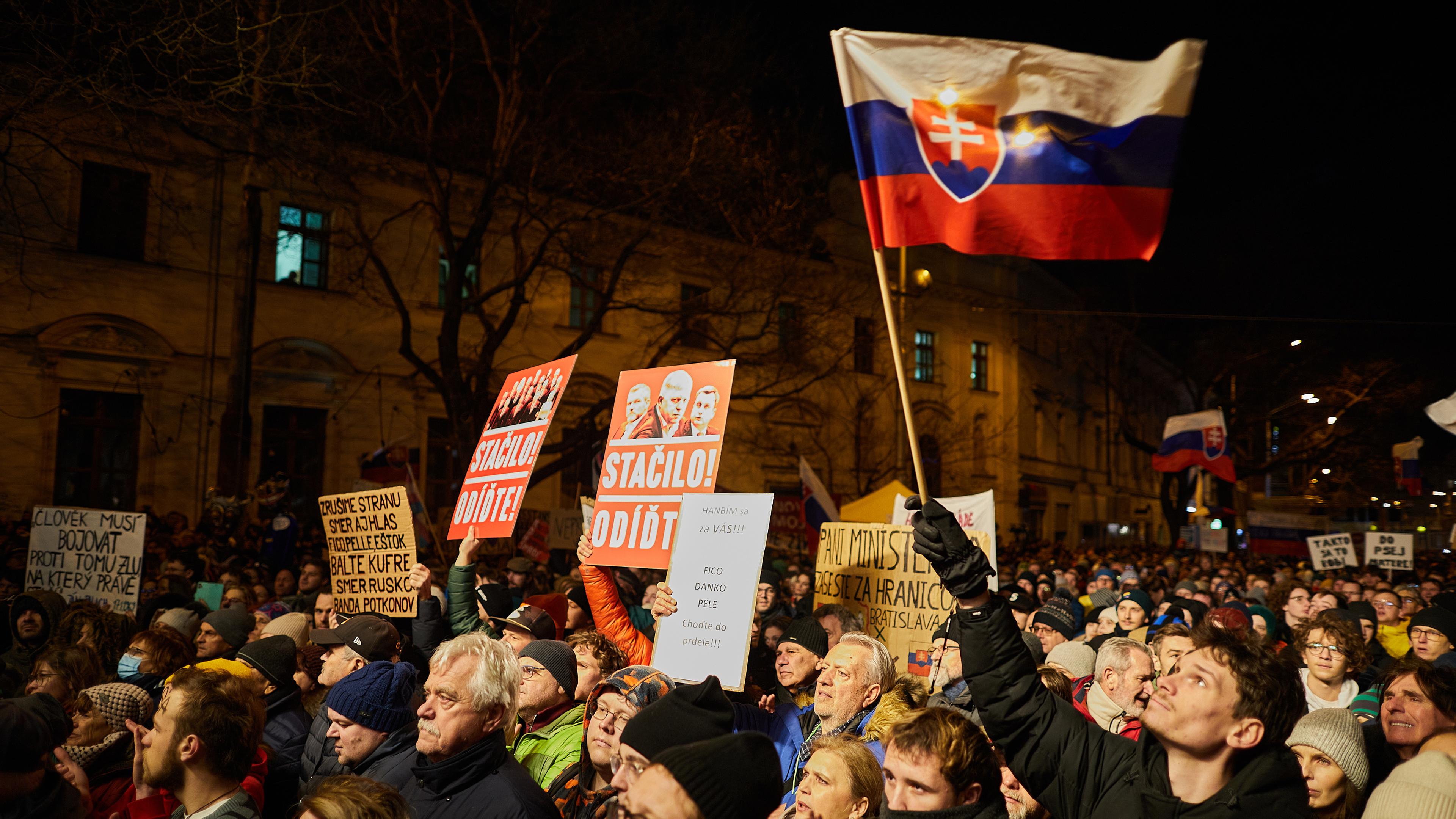 Menschen versammeln sich für eine Demonstration in Bratislava gegen die Regierung in der Slowakei. Man sieht eine Person mit slowakischer Flagge.