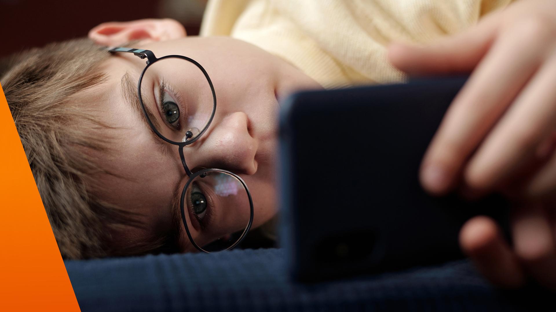 Kind schaut ins Smartphone