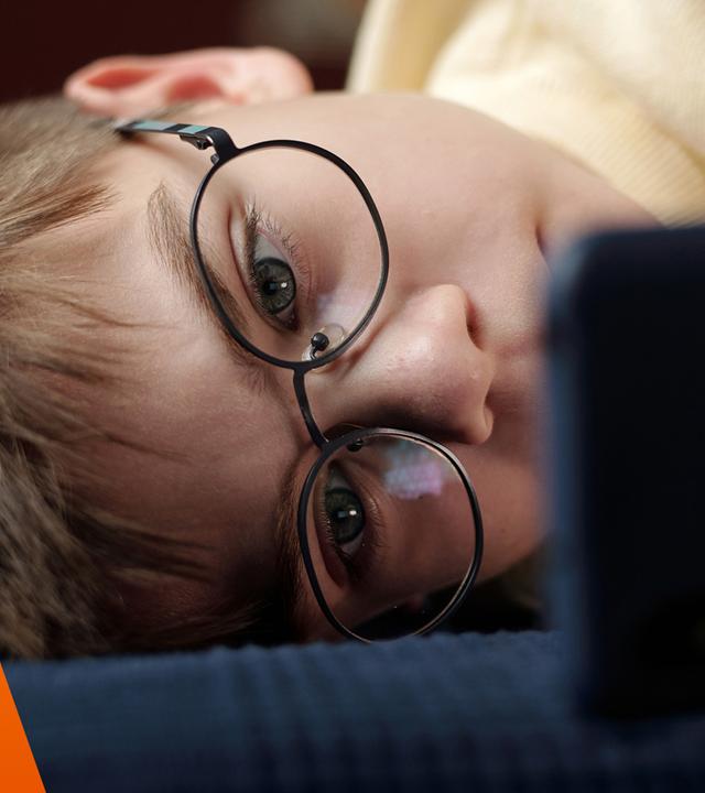 Kind schaut ins Smartphone