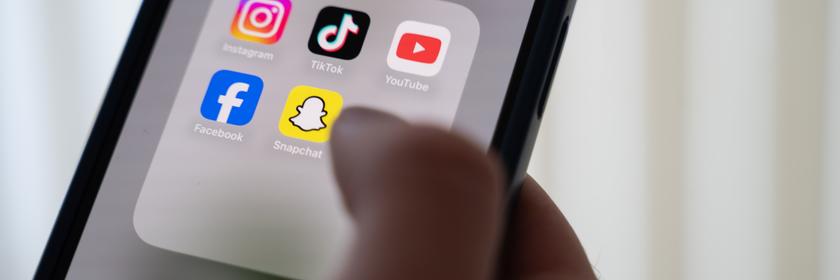 Social Media Apps auf einem Handy, ein Finger tippt auf das Display