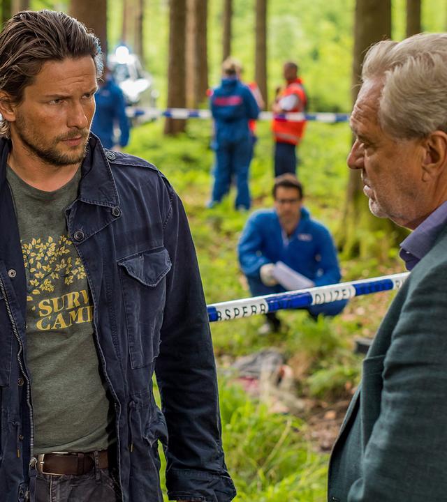 Arthur Bauer (Gerd Silberbauer) und Resi Schwaiger (Mersiha Husagic) befinden sich im Wald an einem Tatort. Zwischen ihnen steht Uwe Zöllner (Bert Tischendorf), der sich mit Arthur Bauer unterhält.