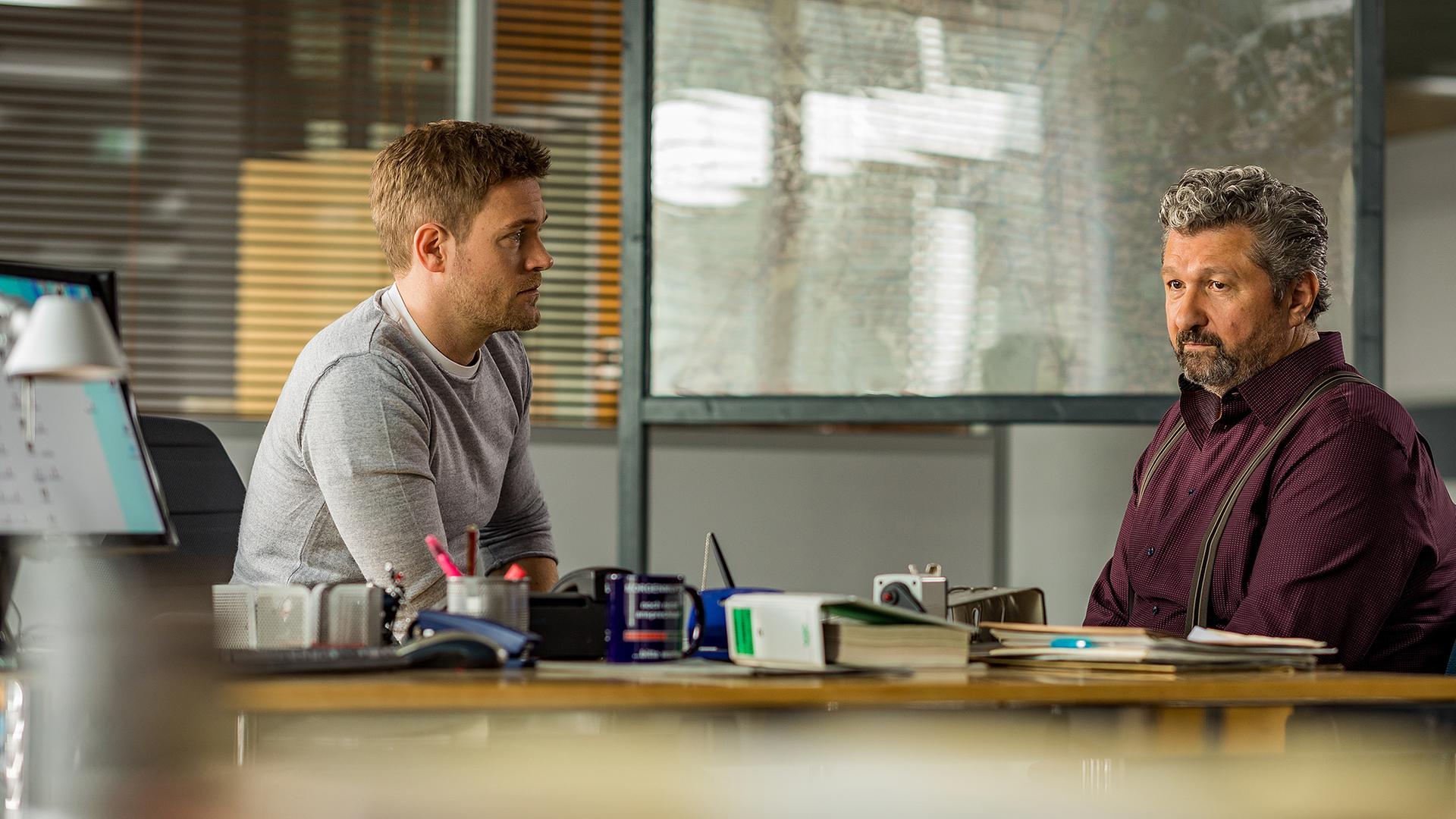 Im Revier sitzt Dominik Morgenstern (Joscha Kiefer) an seinem Schreibtisch, seitlich gegenüber sitzt Osman Gülpek (Auykut Kayacik) und schaut ins Leere