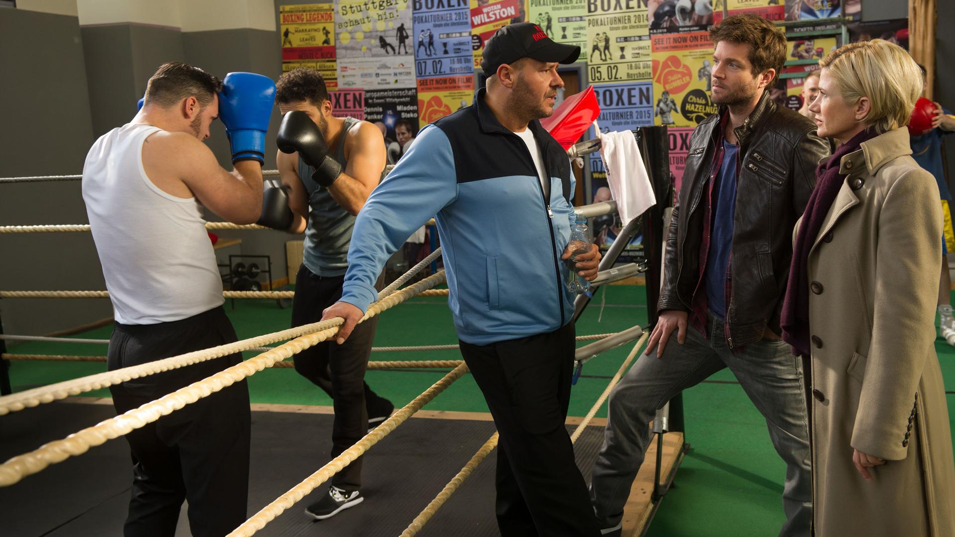 "SOKO Stuttgart - Faustrecht": Martina Seiffert (Astrid M. Fünderich) befindet sich mit ihrem Kollegen Jo Stoll (Peter Ketnath) in einem Boxstudio. Sie sprechen mit dem Trainer Ingo Koos (Willi Herren), während Erik Thiel (Karim Günes) mit einem Sparringspartner trainiert. An der Wand im Hintergrund hängen viele bunte Boxplakate.