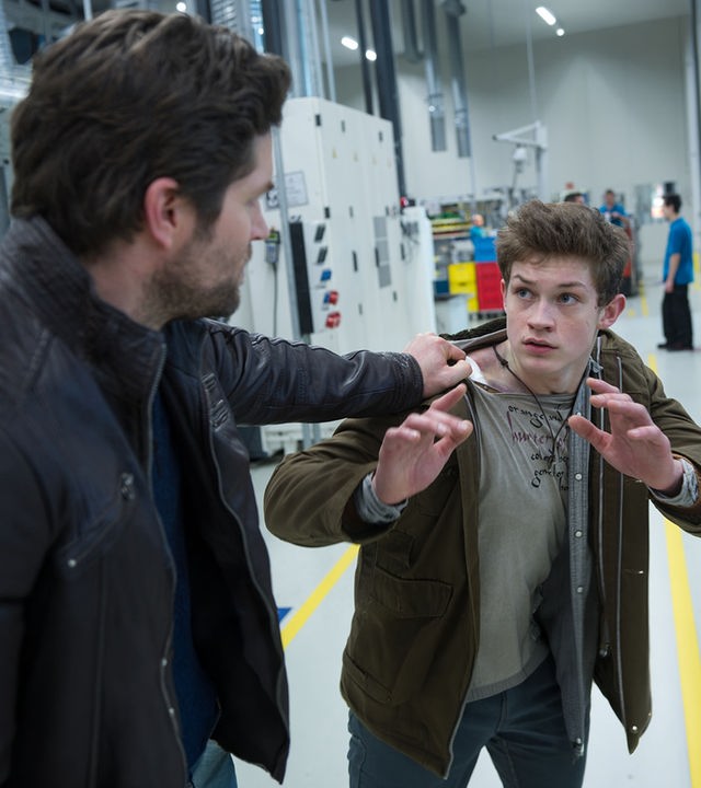 "SOKO Stuttgart - Kaiserbaby": Jo Stoll (Peter Ketnath) hat den jungen David Engstrom (Damian Hardung) am Anorak gepackt. Beide befinden sich in einer Werkshalle. Im Hintergrund sind Werksarbeiter zu sehen.