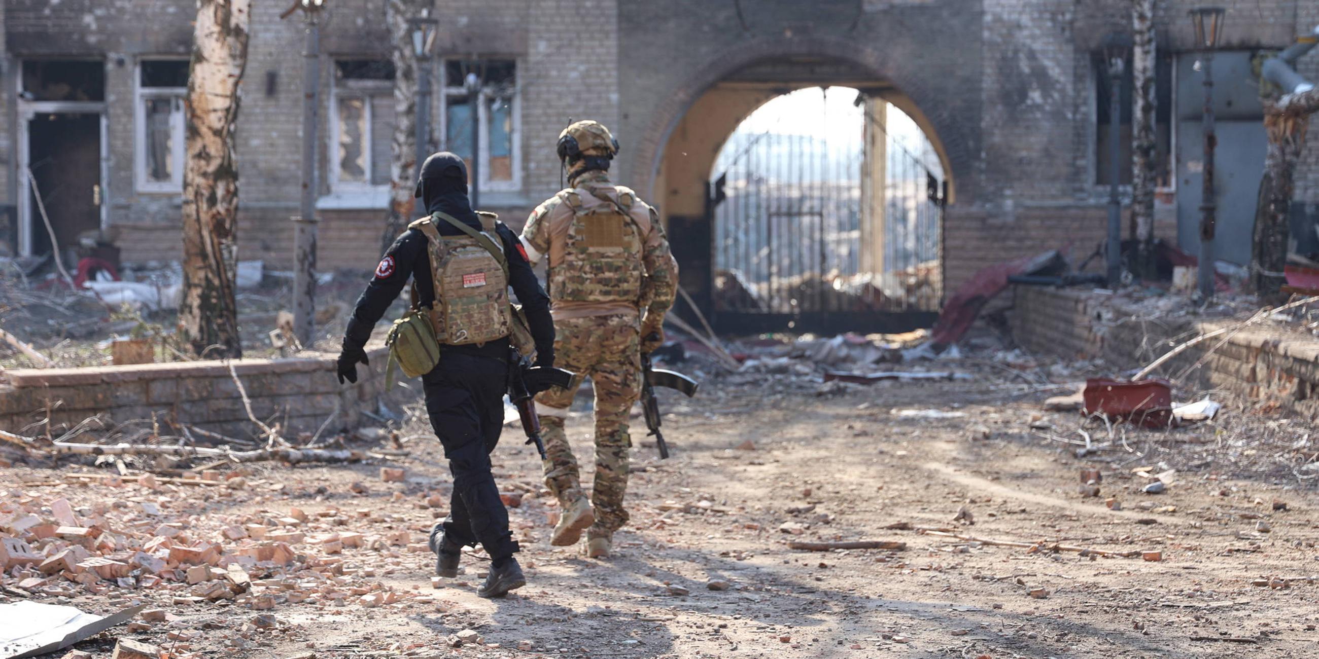 Soldaten der Wagner-Gruppe bewachen ein Gebiet außerhalb von Wohnblöcken in der Stadt Bachmut