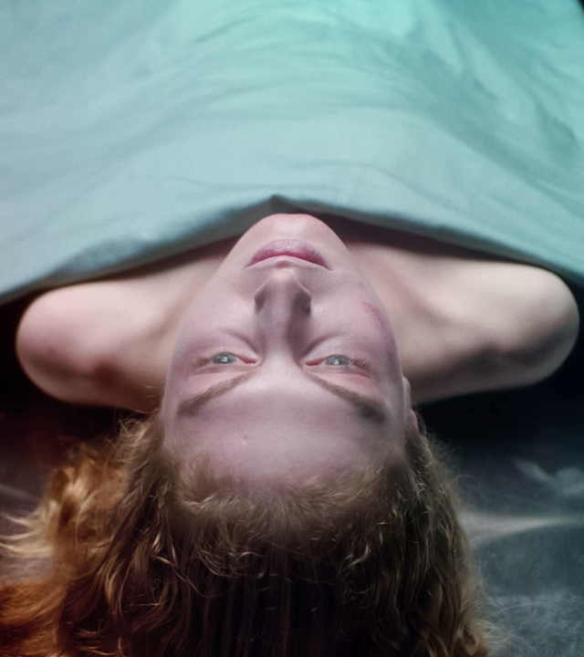 Die Leiche einer Frau liegt auf einem Obduktionstisch. Ihr Kopf und die Schulterpartie ragen unter einem Tuch hervor.