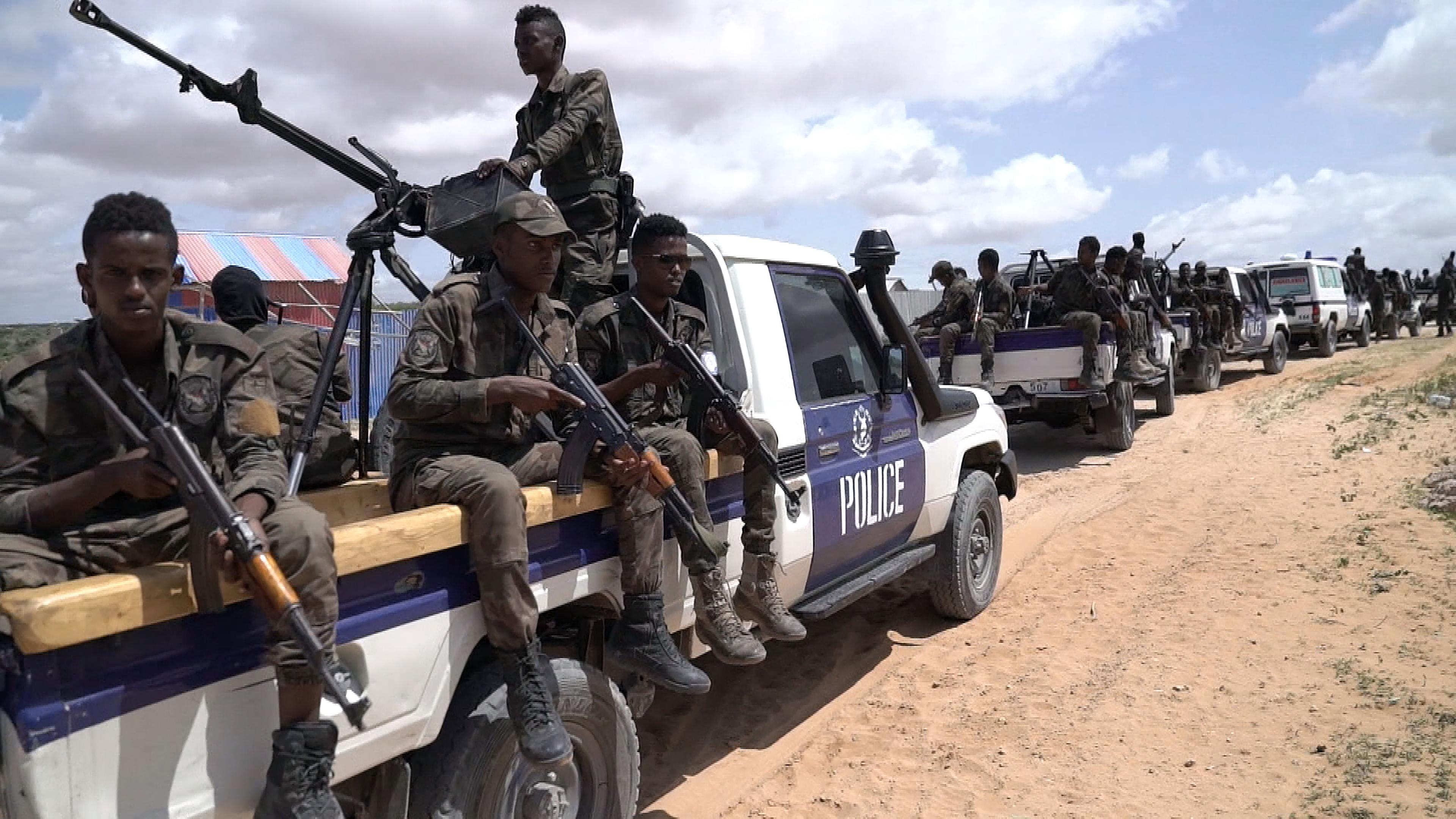 Somalia am Abgrund - Leben mit Terror und Gewalt": Bewaffnete Männer auf Polizeiwagen fahren auf einer unbefestigten Straße im Konvoi.