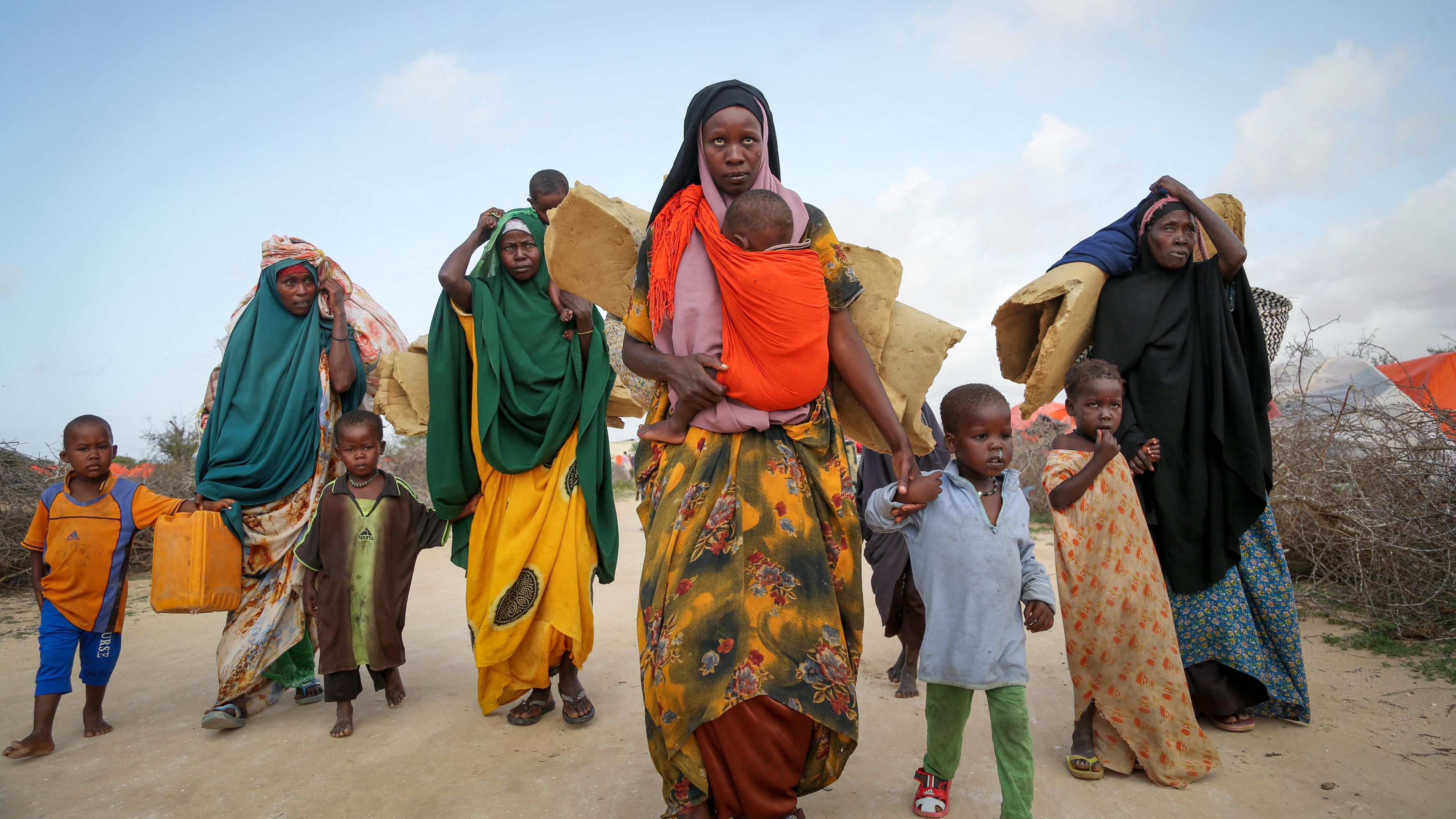 Somalier, die aus den von der Dürre betroffenen Gebieten geflohen sind, tragen ihre Habseligkeiten, als sie in einem behelfsmäßigen Lager für Vertriebene am Stadtrand von Mogadischu ankommen. 