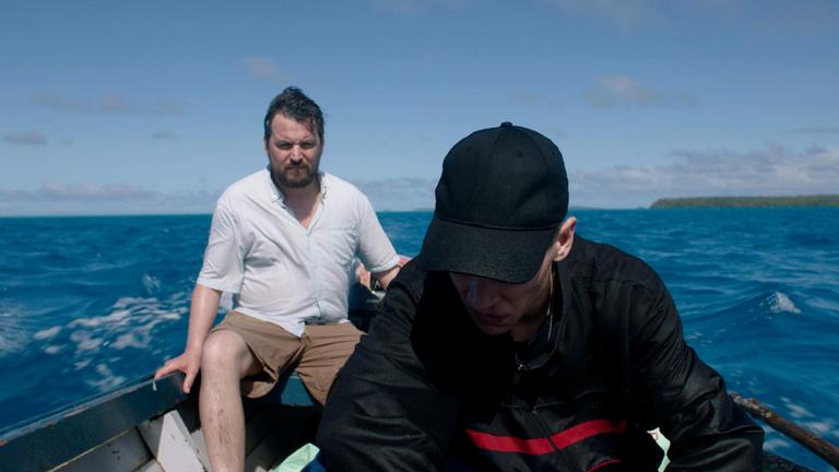 "Somewhere in Tonga": Wolski (Sascha Alexander Gersak) fährt mit Marcel (Luis Pintsch) in einem offenen Boot zur einsamen Insel.