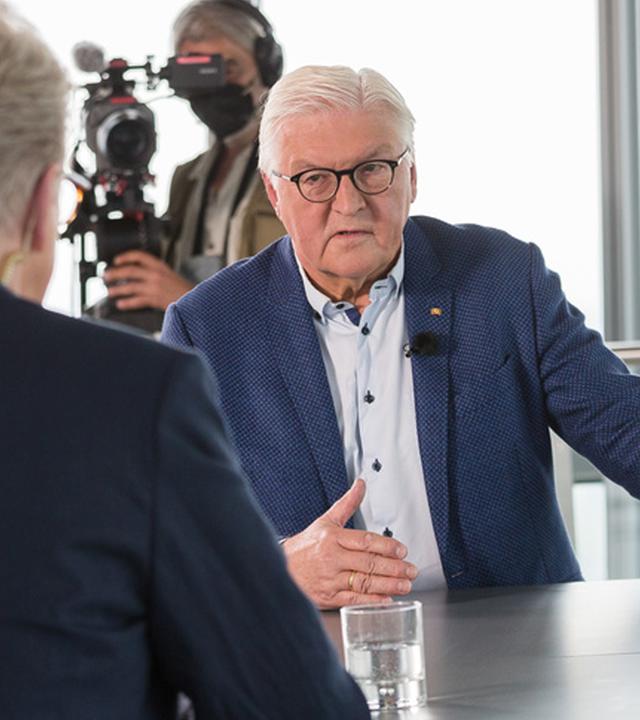 Frank-Walter Steinmeier und Theo Koll sitzen sich an einem Tisch zum Gespräch gegenüber.