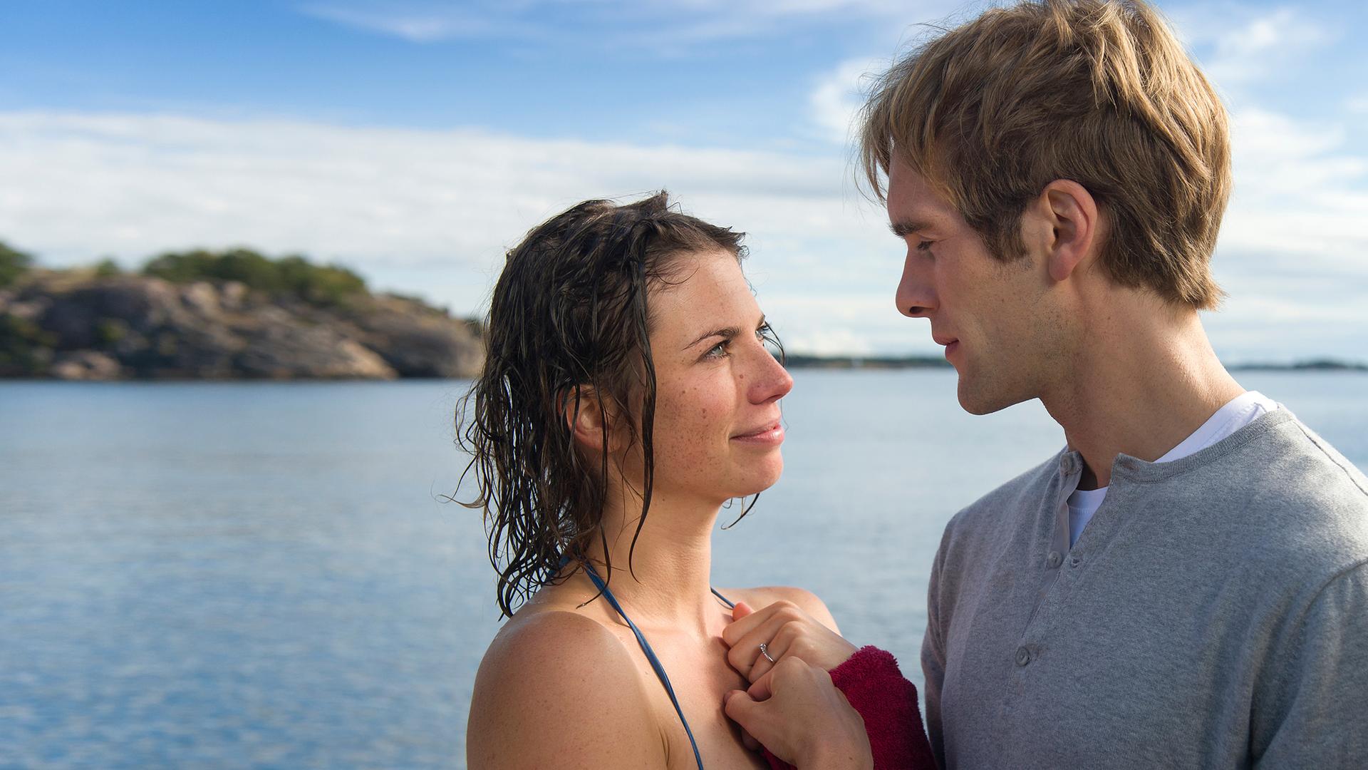 Britta Ingerson (Anna Rot) und Bertil Hanson (Mathis Landwehr) stehen sich vor dem See eng gegenüber und schauen sich in die Augen.