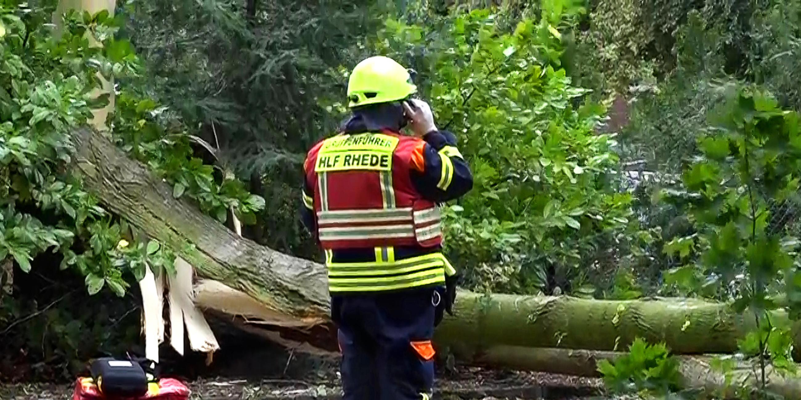 Ein Feuerwehrmann steht vor der abgedeckten Leiche einer Frau, die während des Sturms "Poly" von einem umgestürzten Baum tödlich verletzt wurde.