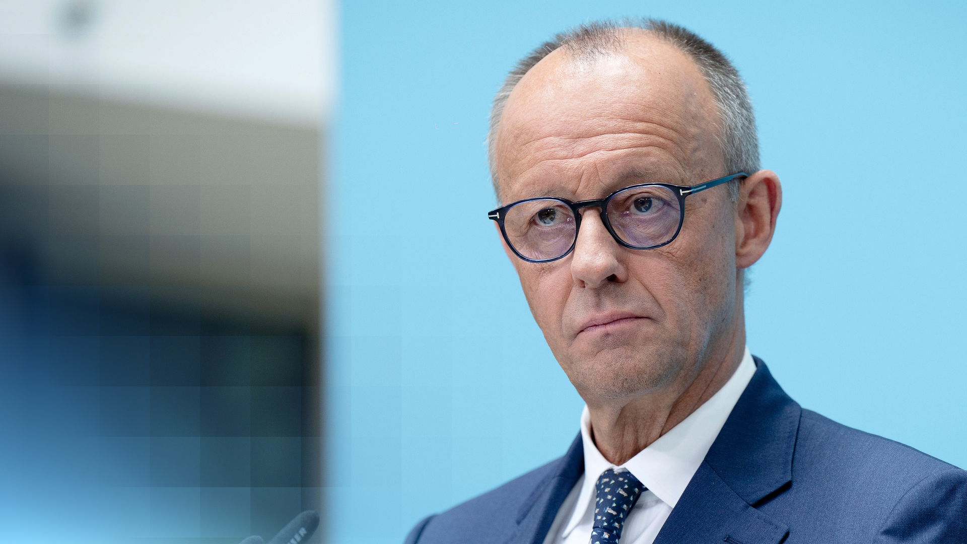Bundeskanzler Friedrich Merz, der nachdenklich/unzufrieden an der Kamera vorbeischaut