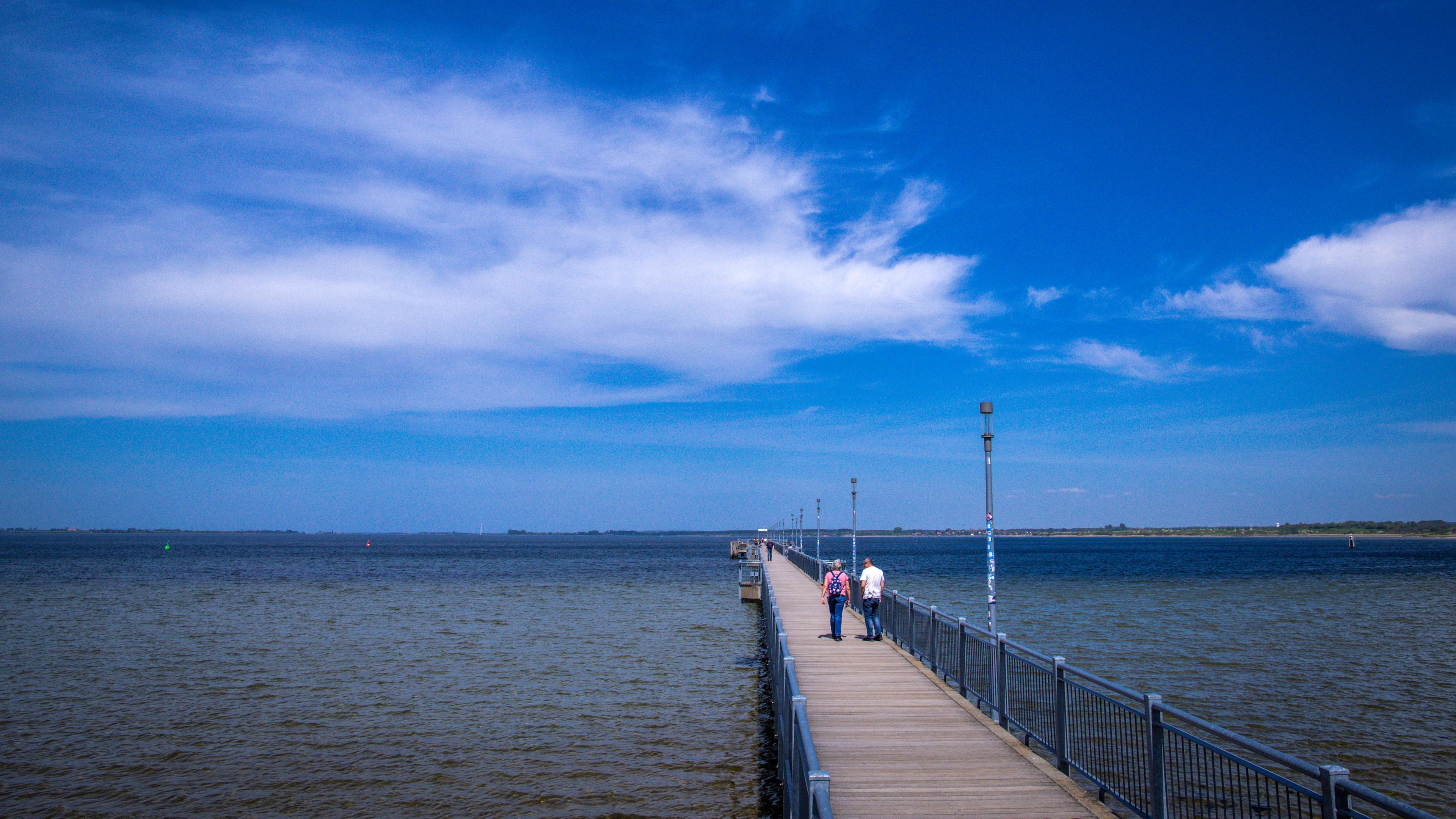 Mecklenburg-Vorpommern, Wismar: Spaziergänger sind auf der Seebrücke an der Ostseeküste unterwegs.