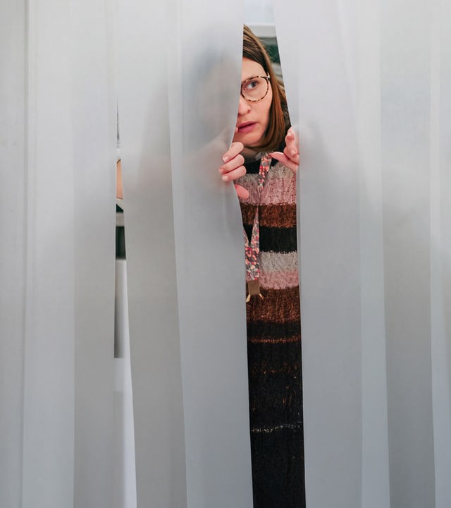 "Nine to Five - Das Amt - Sonntag Nichts vor": Conny (Lisa Hrdina) blickt durch einen Lamellenvorhang.