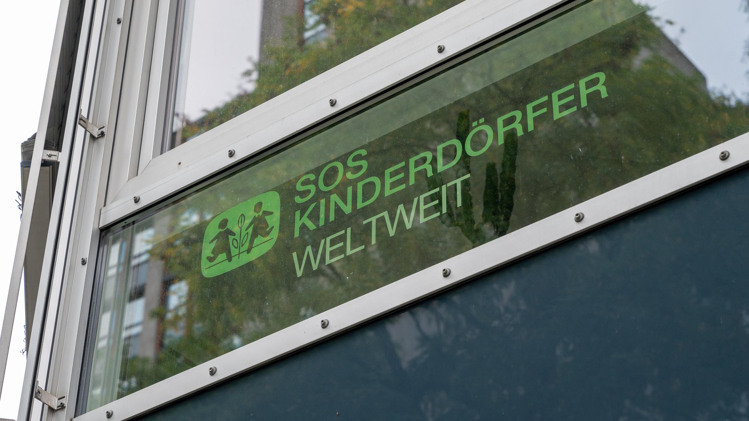 Der Schriftzug „SOS Kinderdörfer - Weltweit“ steht an einem Fenster.