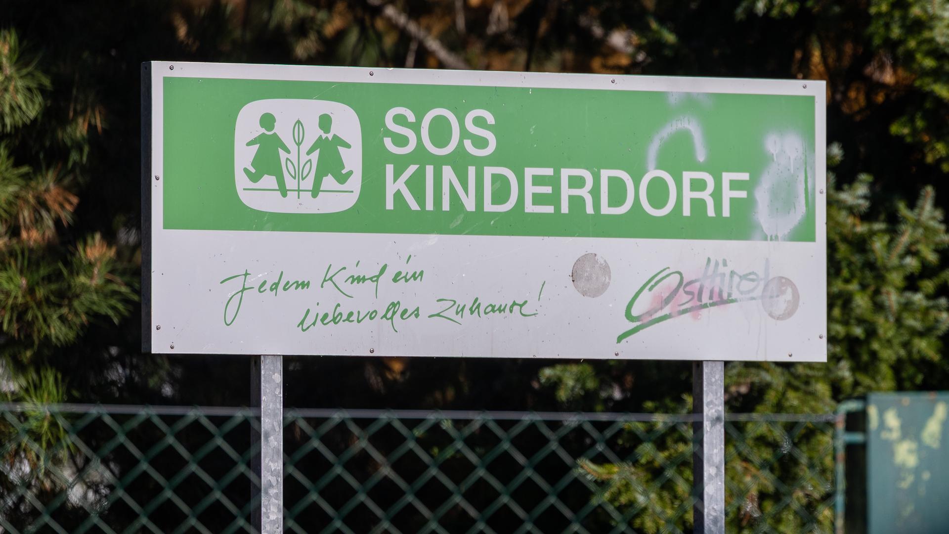 Auf einem großen Schild steht SOS-Kinderdorf