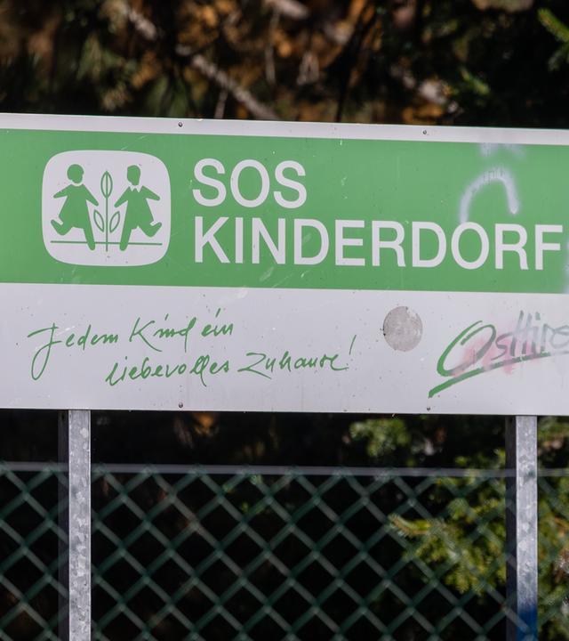 Auf einem großen Schild steht SOS-Kinderdorf