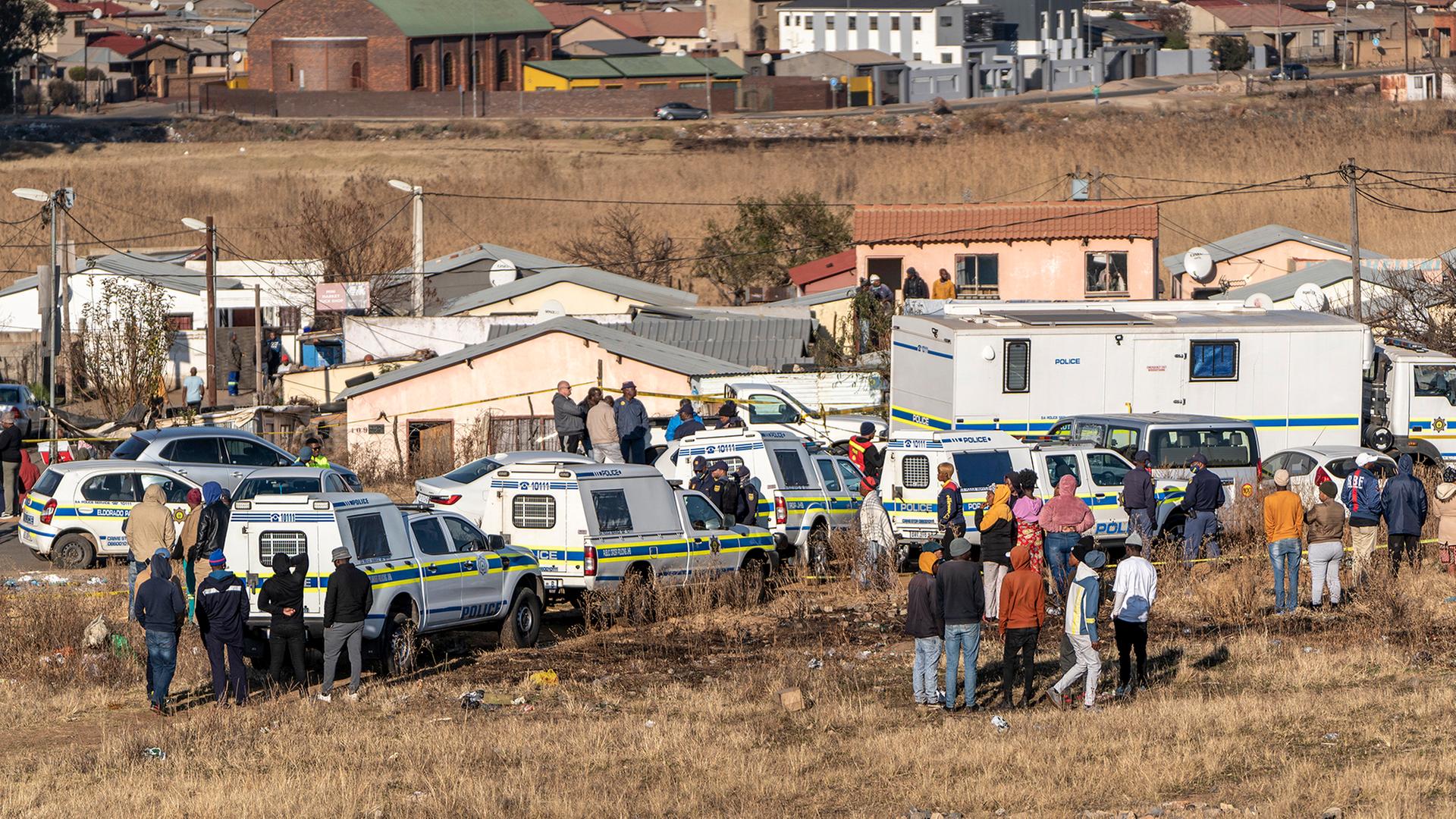 Menschen am Tatort der Schießerei in einer Nachtbar in Soweto