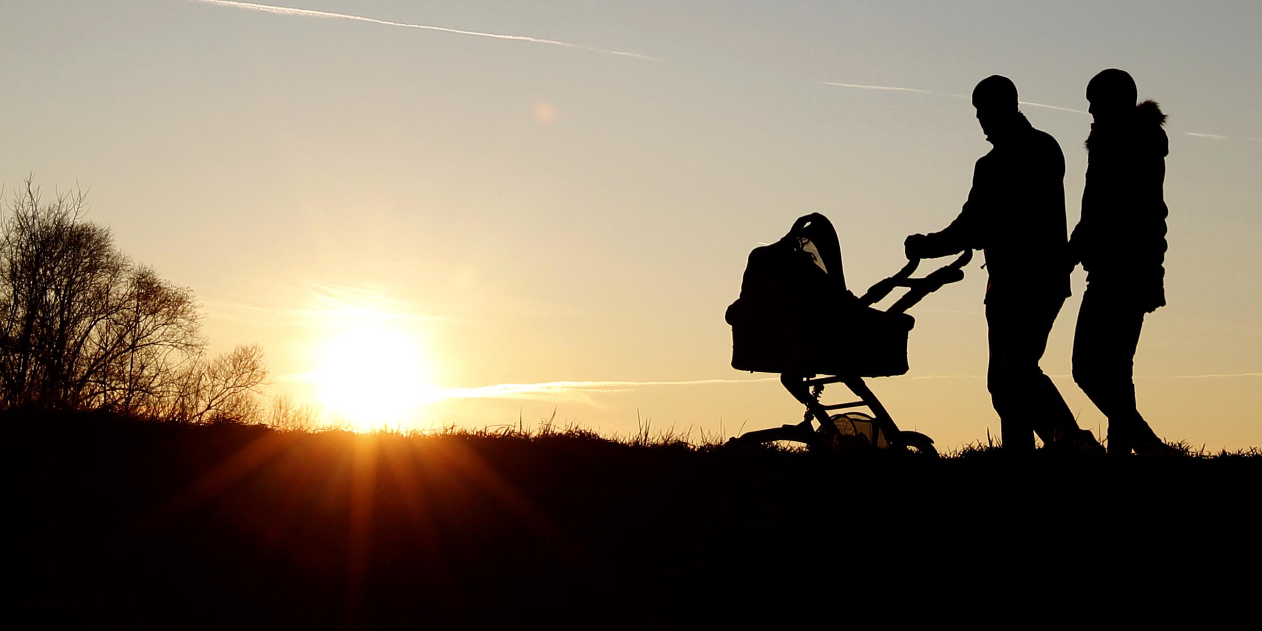 Archiv: Eine Familie geht bei Sonnenuntergang einen Weg entlang
