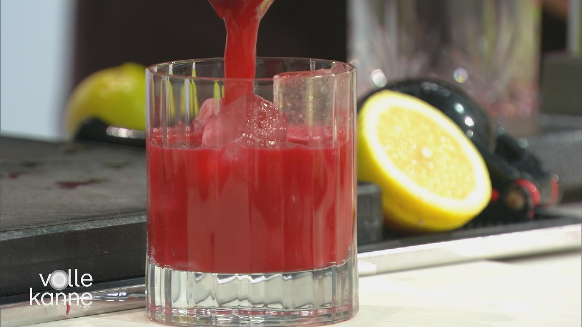 In ein Glas wir eine rote Flüssigkeit eingefüllt