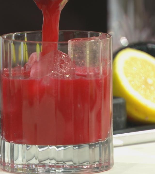 In ein Glas wir eine rote Flüssigkeit eingefüllt