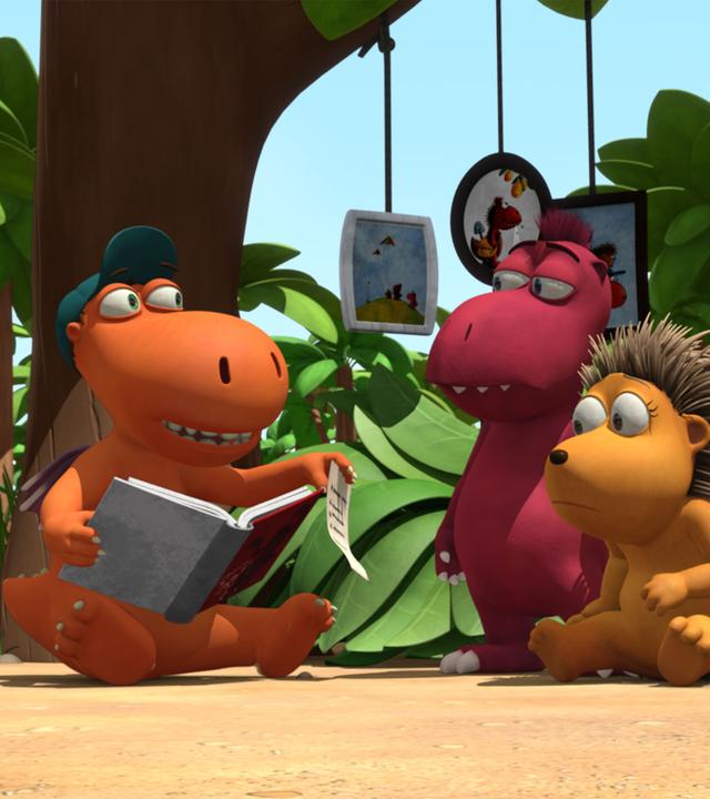 Kokosnuss liest Oskar und Matilda aus einem Buch vor.