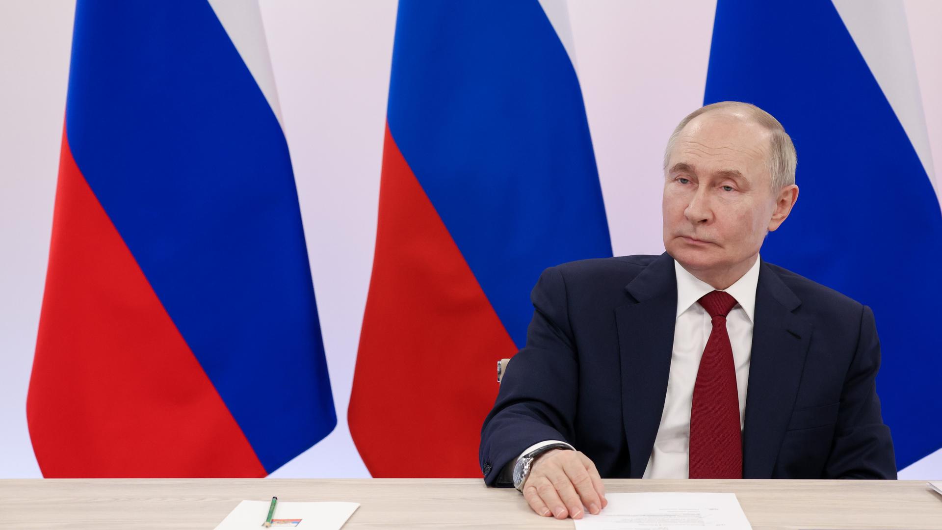 Putin ist vor einer Karte der Ukraine zu sehen. 