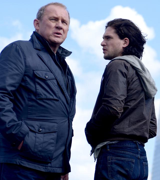 Vor der Hochhauskulisse von London stehen sich Harry (Peter Firth) und Will (Kit Harington) gegenüber