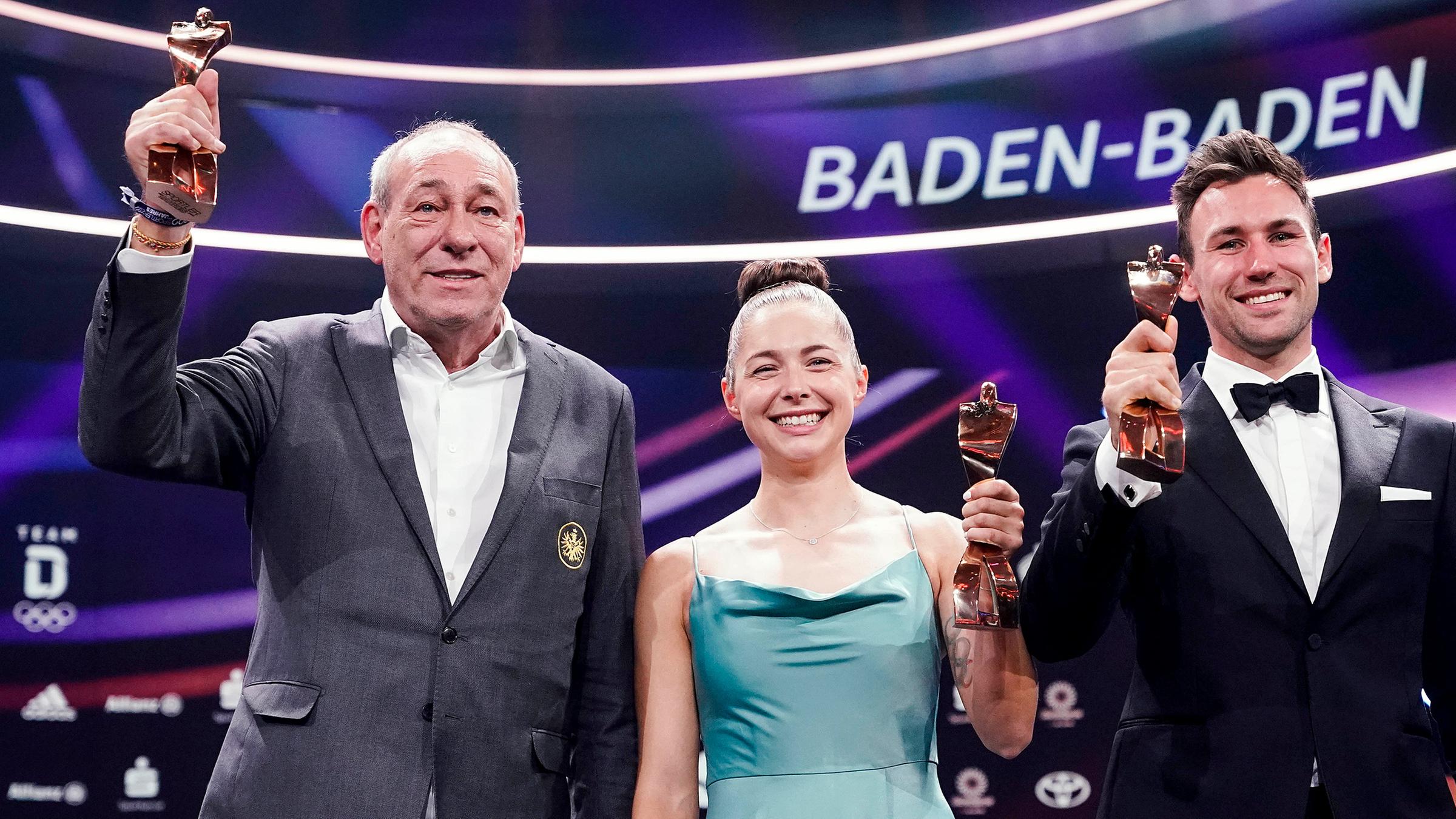 Peter Fischer (l-r), Präsident des Fußballvereins Eintracht Frankfurt, als Preisträger für die ·Mannschaft des Jahres·, die Sprinterin Gina Lückenkemper, diesjährige ·Sportlerin des Jahres·, und der Zehnkämpfer Niklas Kaul, diesjähriger ·Sportler des Jahres·, stehen mit dem Preis auf der Bühne.